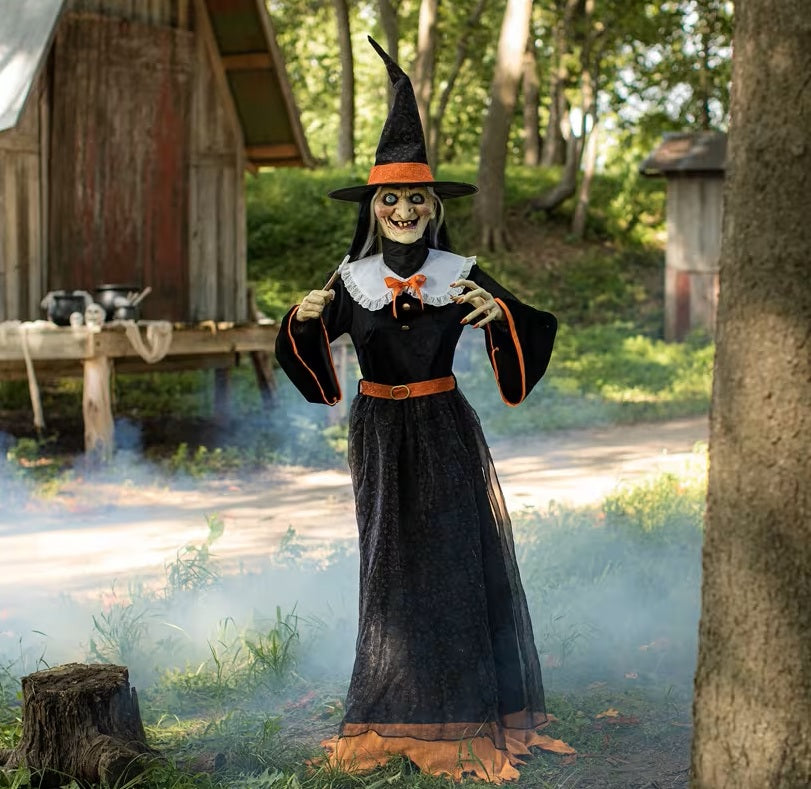 Halloween decoration of a witch in a forest setting with smoke effect