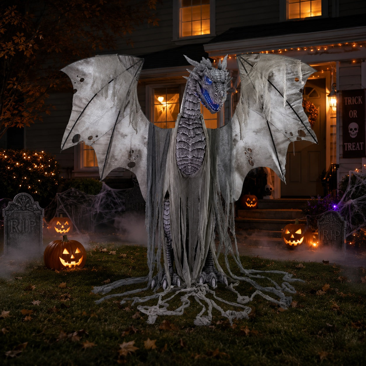 Halloween decorative dragon with pumpkins and tombstones in front of a house.