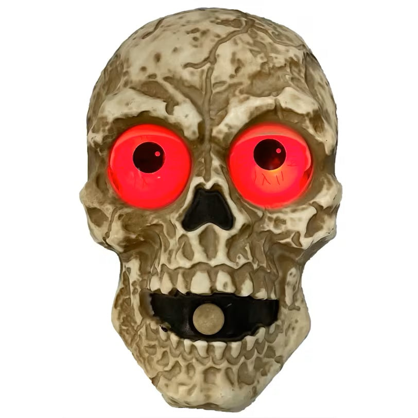 Skull-shaped doorbell with red glowing eyes on a white background
